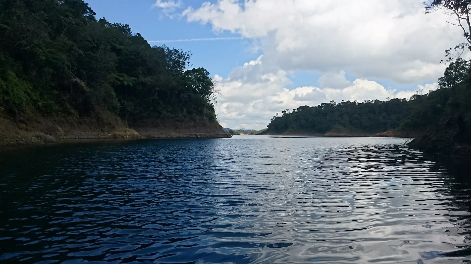 Un pescador lanza su caña desde la orilla del embalse en Guatapé.