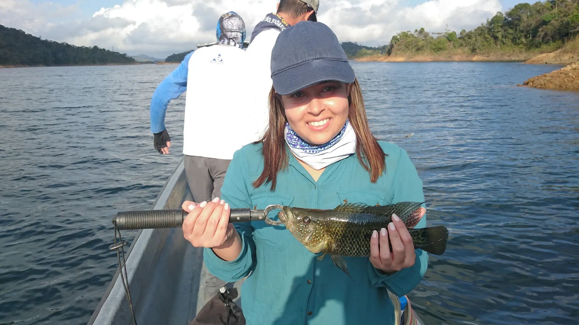 Un black bass es liberado de vuelta al agua tras la captura de Juliana.