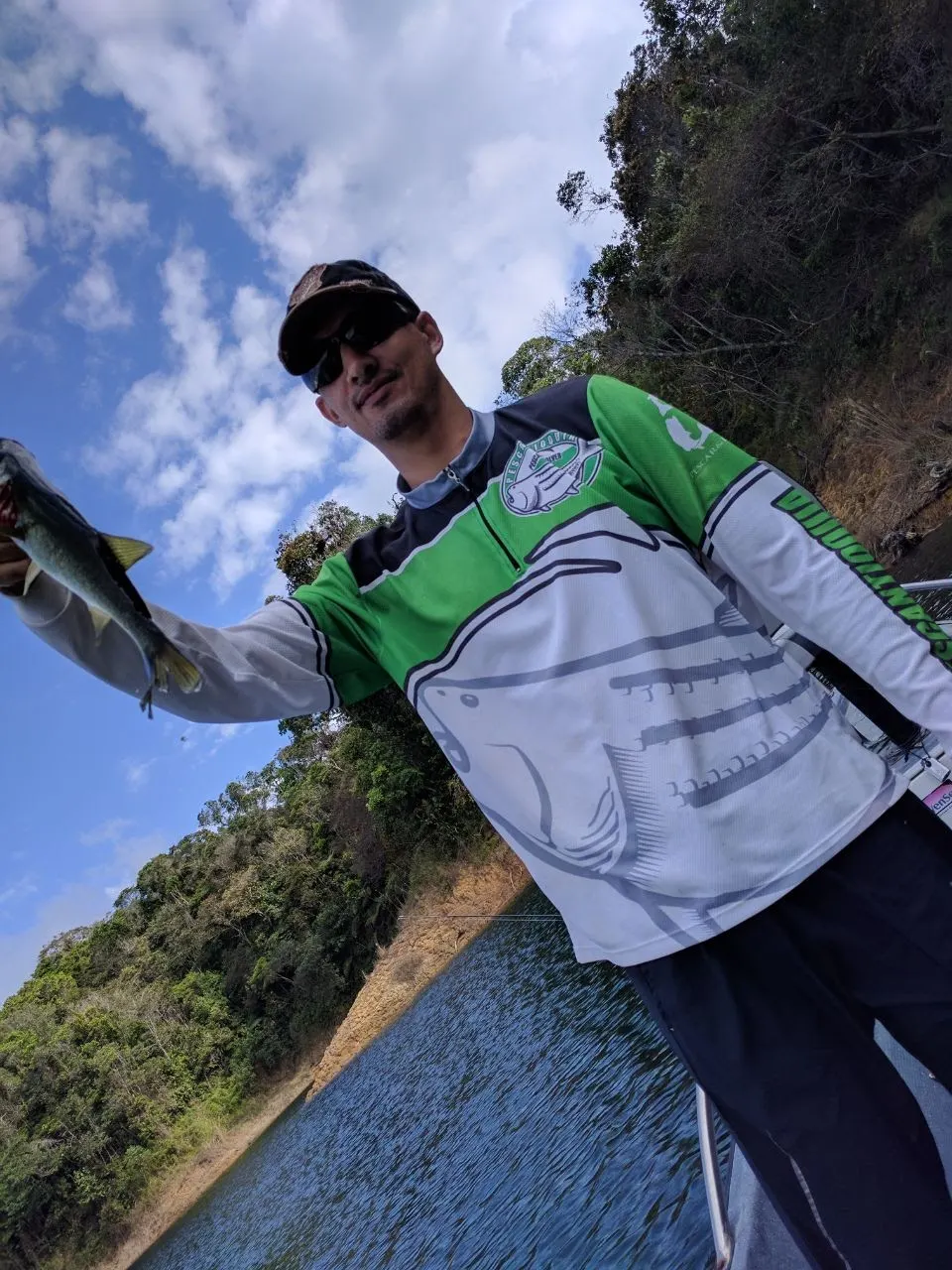 Un pescador sostiene un black bass mediano capturado en el embalse de Guatapé.