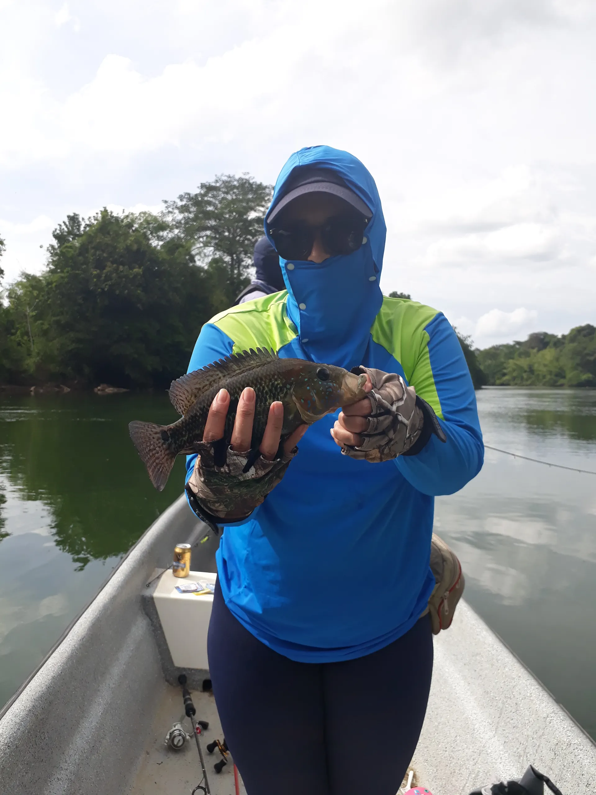Un pescador sostiene una picuda de cuerpo alargado y plateado capturada en el río.