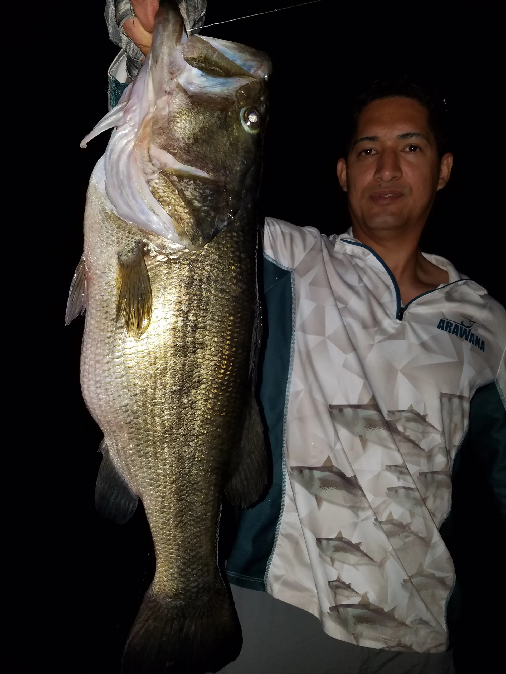 Un pescador sostiene uno de los black bass más grandes capturados en Lake Fork durante la madrugada.