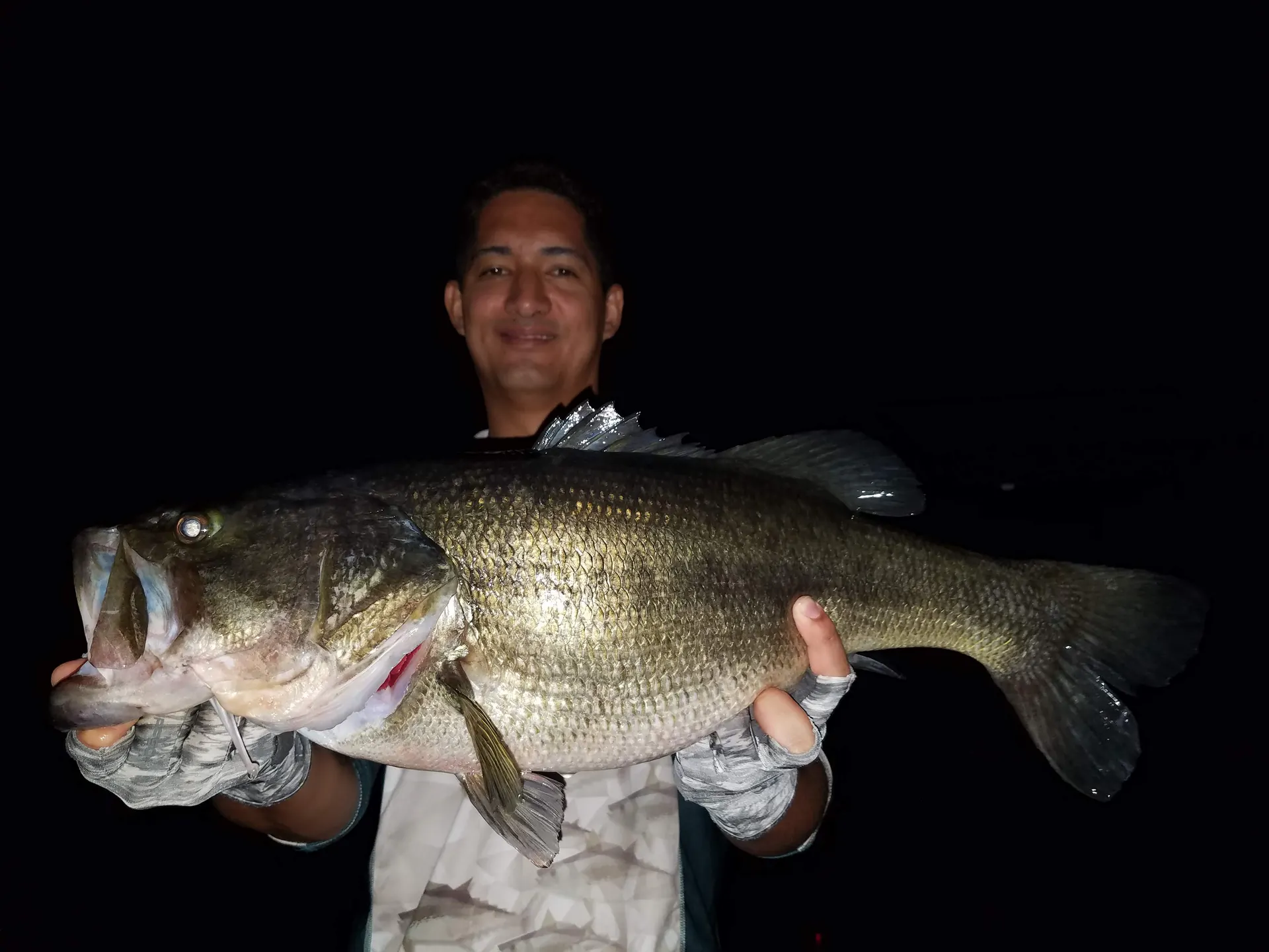 El tercer gran black bass de la madrugada es sostenido con orgullo junto al bote.