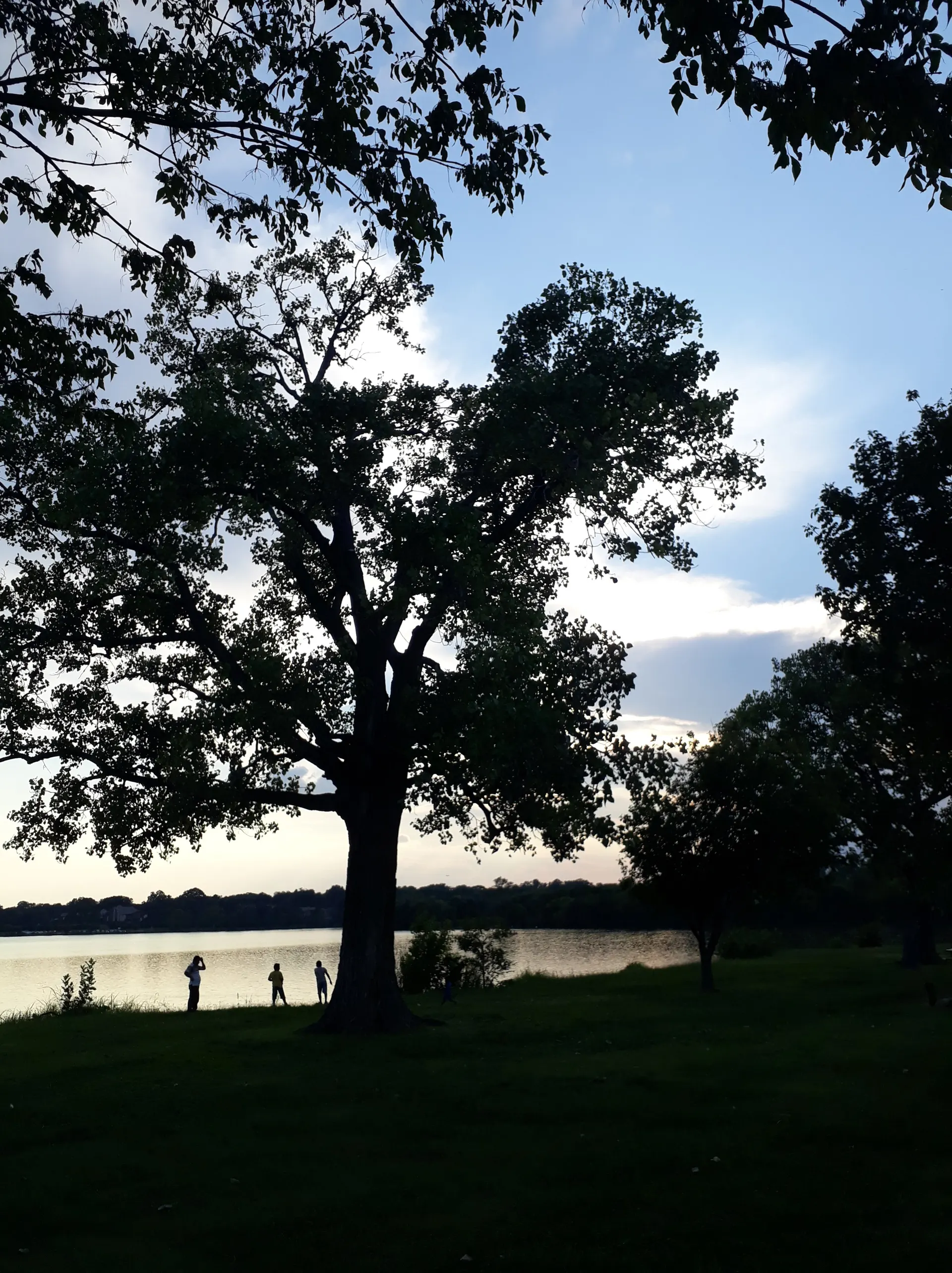 El sol se pone sobre Lake Fork tiñendo el cielo y el agua de tonos naranjas.