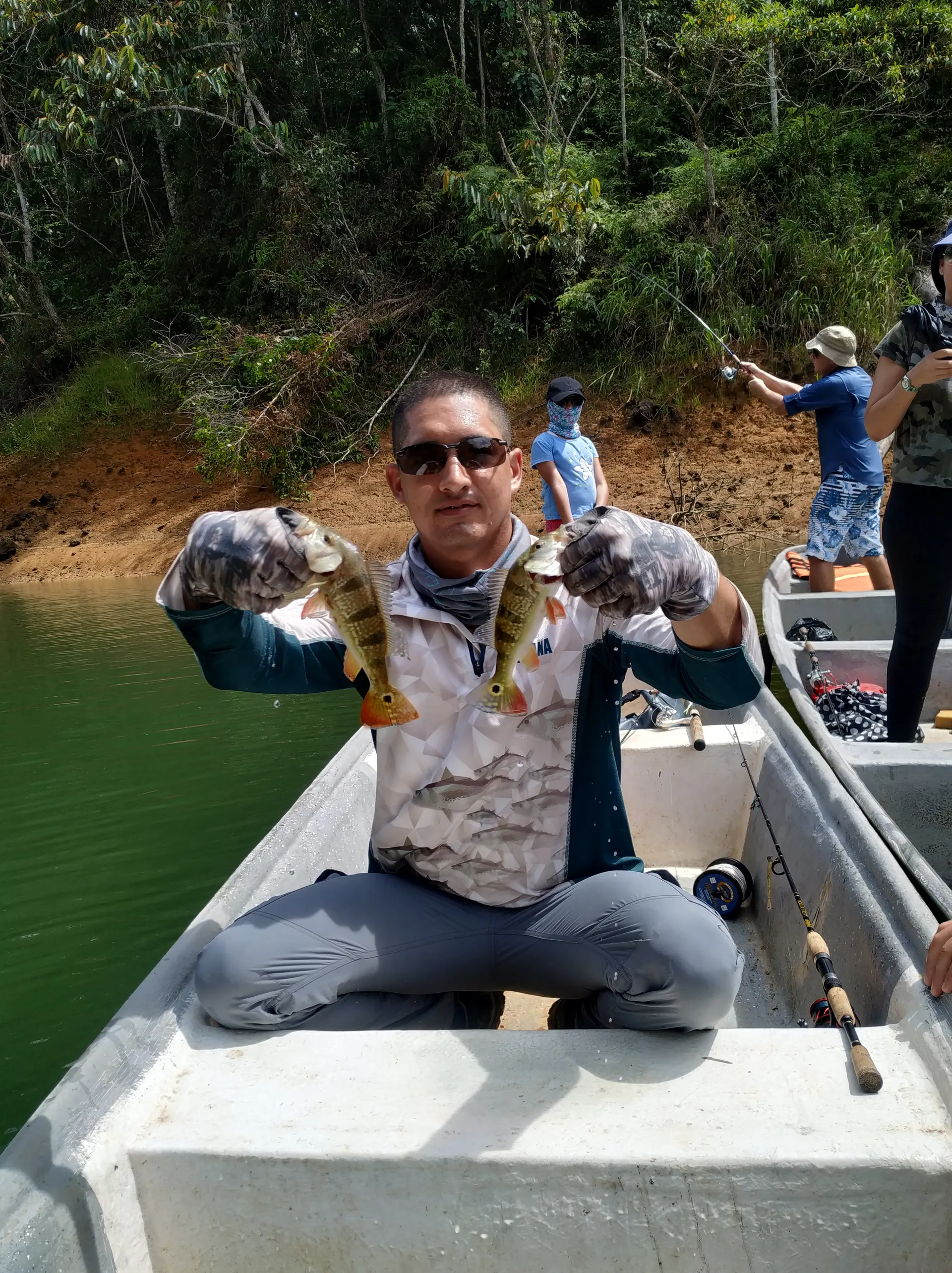 Un pescador levanta un tucunare mediano capturado en el embalse de Playas.