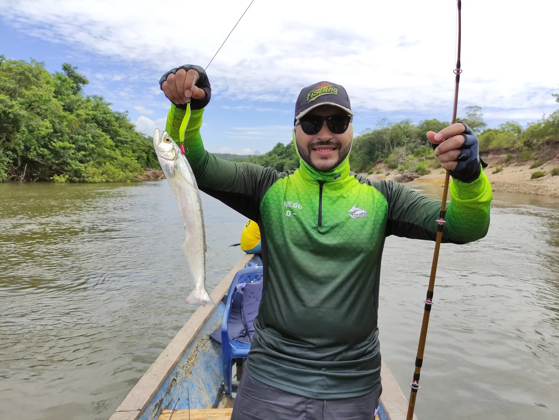 Un pescador levanta un payarín de cuerpo delgado sobre el bote.