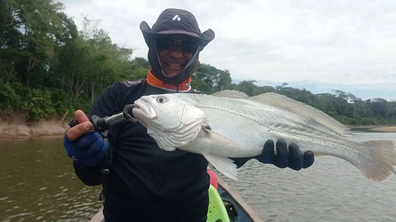 Pablo sostiene una payara con sus colmillos característicos visibles.