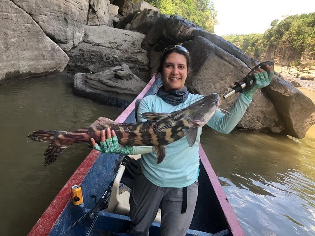 Sara sostiene un bagre capturado en uno de los otros botes de la expedición.