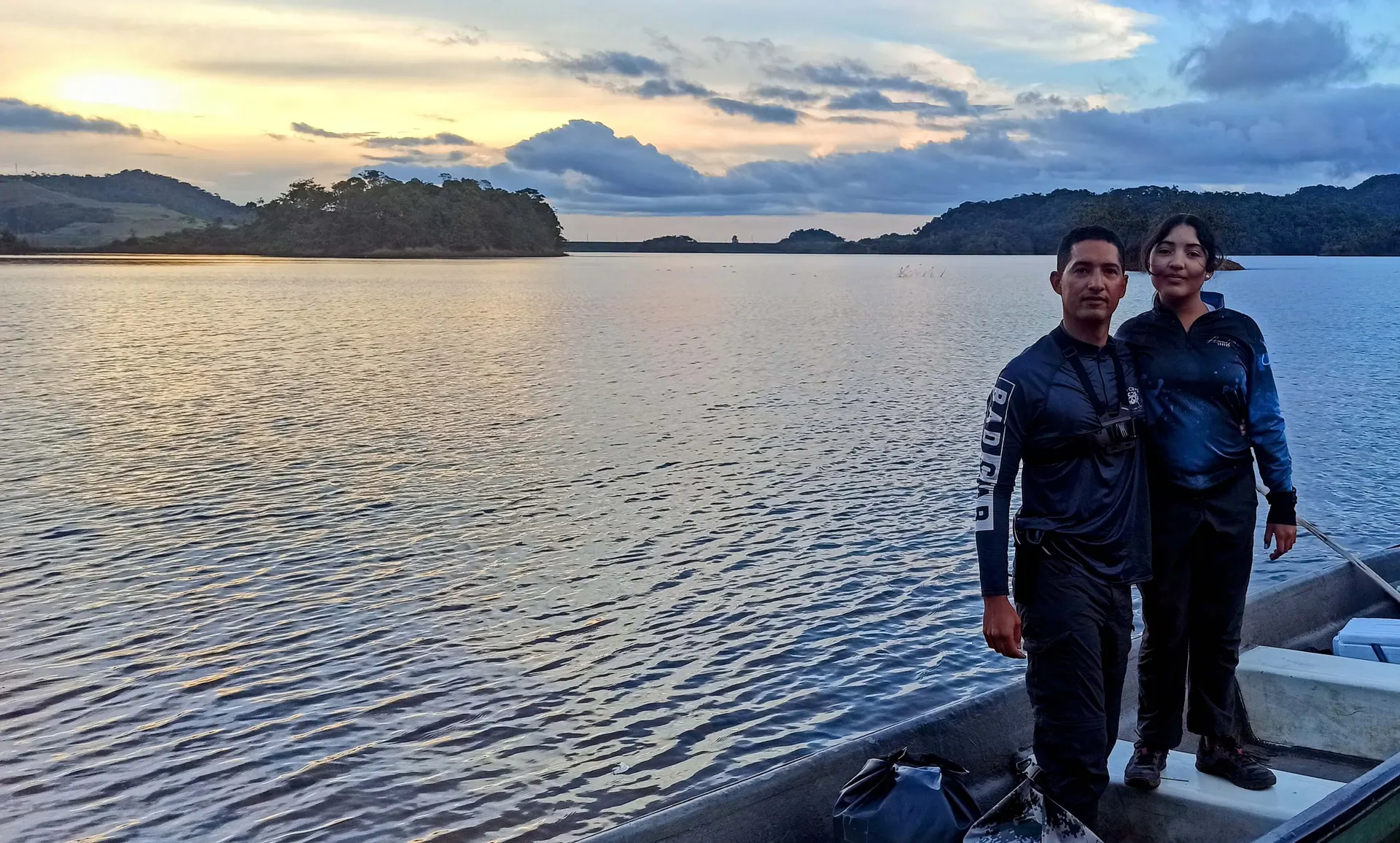 El sol se pone sobre el embalse de Jaguas, tiñendo el agua y las montañas de tonos dorados.